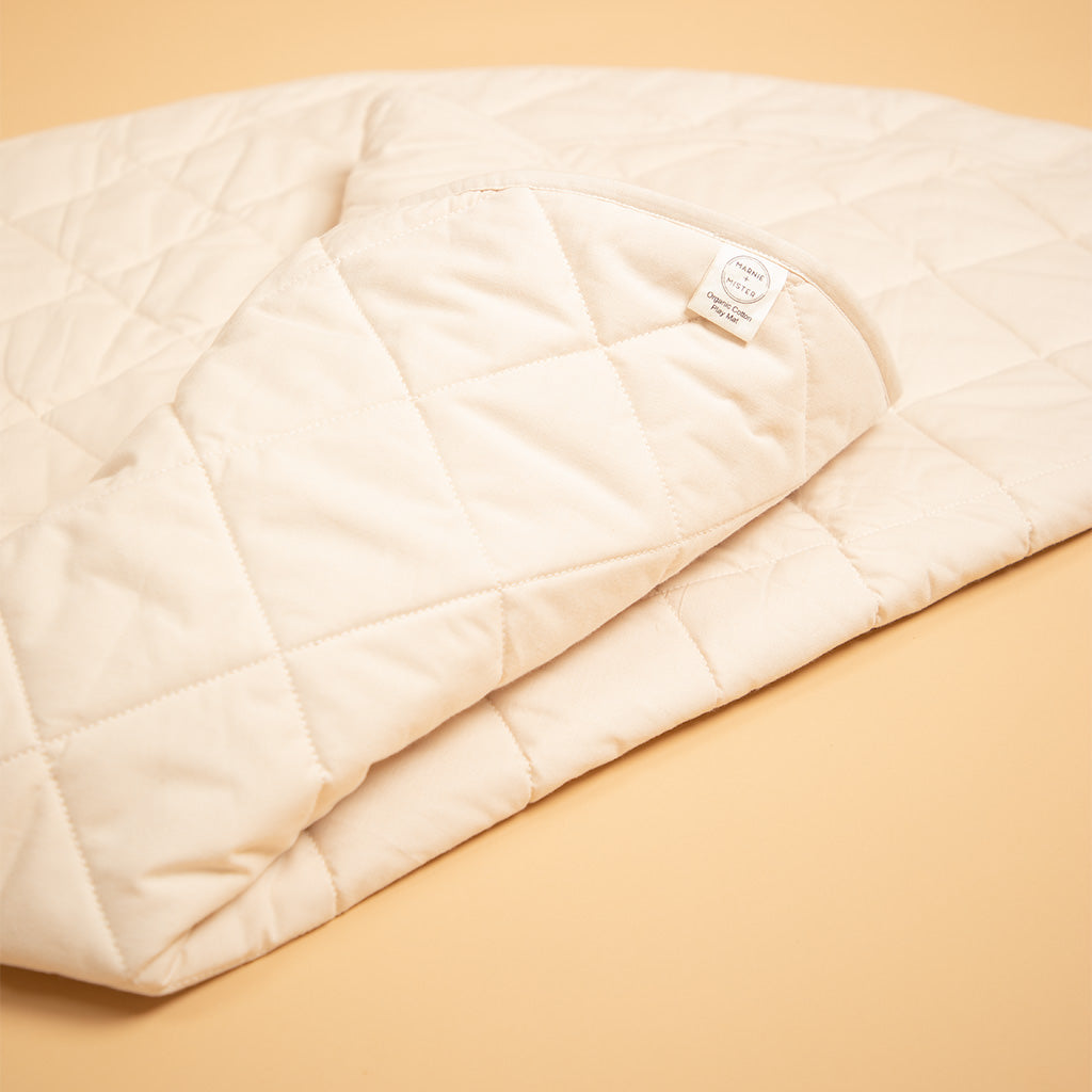 close up of marnie and mister label on organic cotton play mat