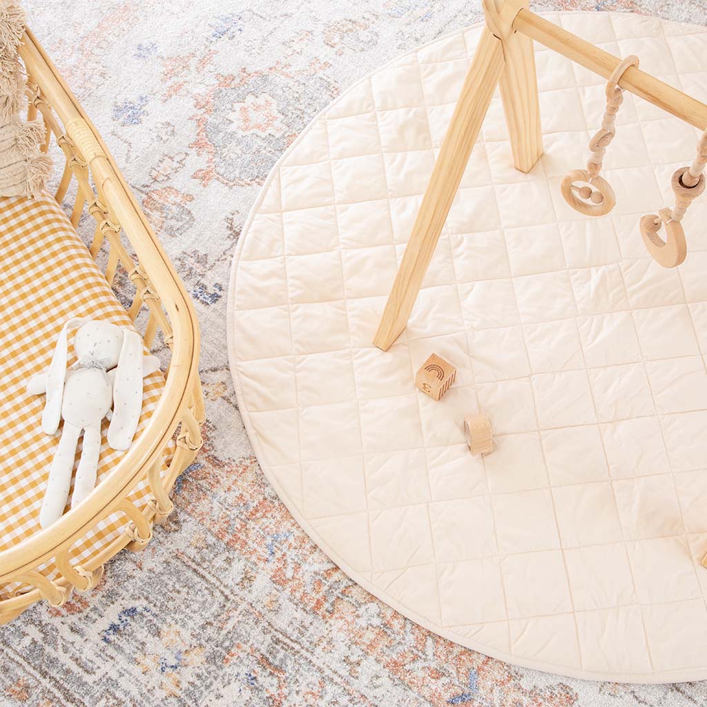 overhead view of organic cotton play mat and wooden activity gym